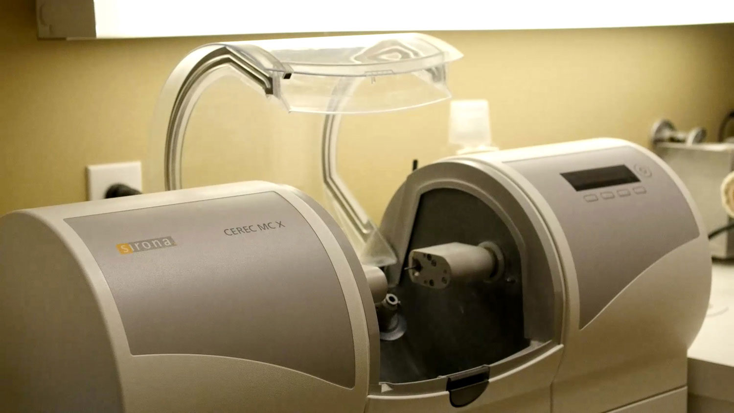 An industrial machine with a clear enclosure, likely used for scientific or medical analysis, sitting on a table.