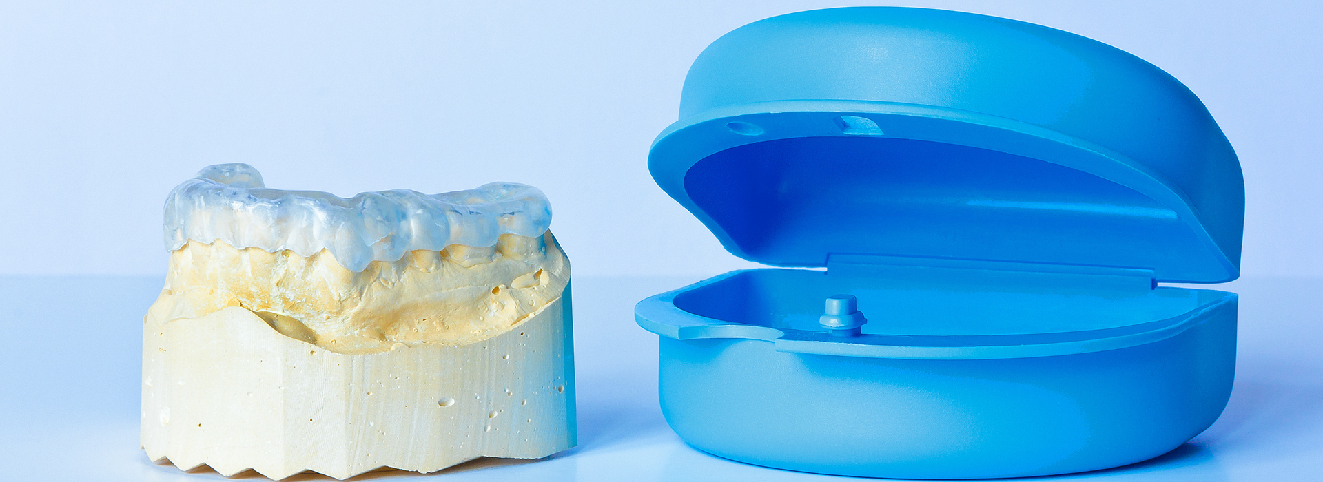 The image shows two blue plastic dental models placed next to each other on a white background.